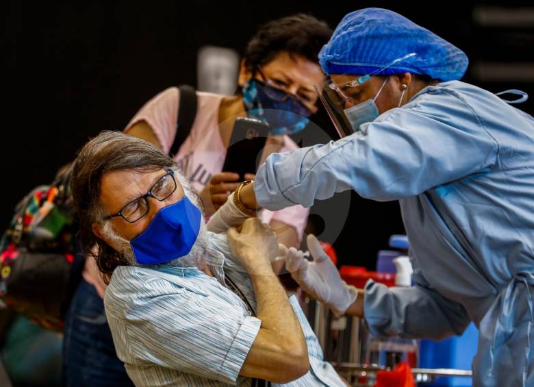 En la fotografía, Neftalí Martínez, de 72 años, recibiendo la vacuna. Al fondo, su acompañante graba un video. FOTO MANUEL SALDARRIAGA