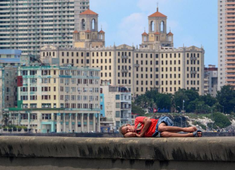 Un hombre duerme en el Malecón de La Habana. Los niveles de pobreza han aumentado drásticamente mientras Cuba enfrenta su peor crisis económica en tres décadas, caracterizada por una grave escasez de alimentos, medicinas y combustible, además de apagones diarios. Foto: AFP