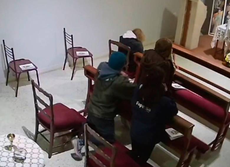Momento en el que el hombre robó la cartera de una mujer mientras estaba arrodillado ante el altar. FOTO CAPTURA DE VIDEO