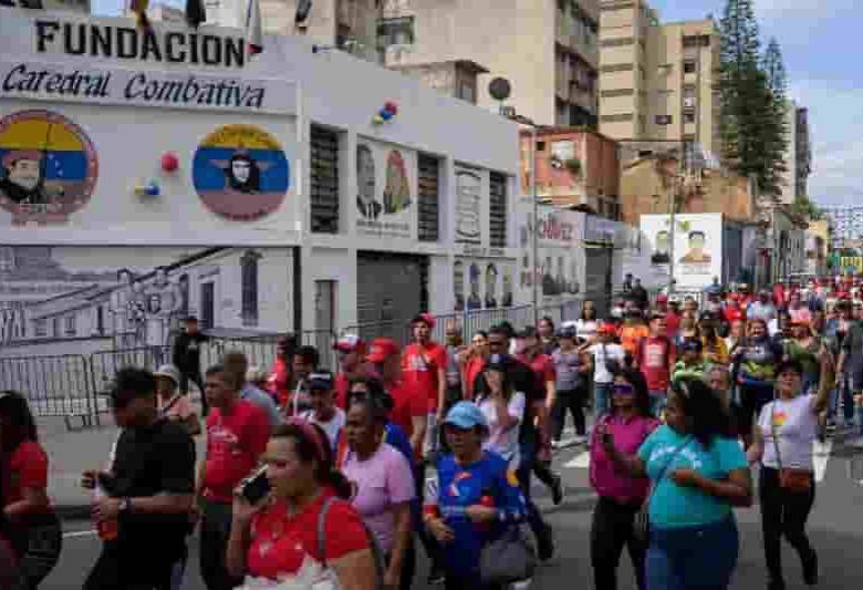 Los partidarios del presidente Nicolás Maduro pasan por la sede de la ‘Catedral Combativa’, un grupo progubernamental conocido como ‘Colectivos’, en el centro de Caracas el 5 de enero de 2025. ‘Somos los defensores de la patria, los defensores de la revolución proceso”, proclama Teodoro Cortez, segundo al mando del ‘Colectivo Catedral’, que responde a las críticas contra estos grupos calificados por la oposición y activistas de derechos humanos como ‘paramilitares’ en el servicio del gobierno. (Foto de Gabriela ORAA/AFP)