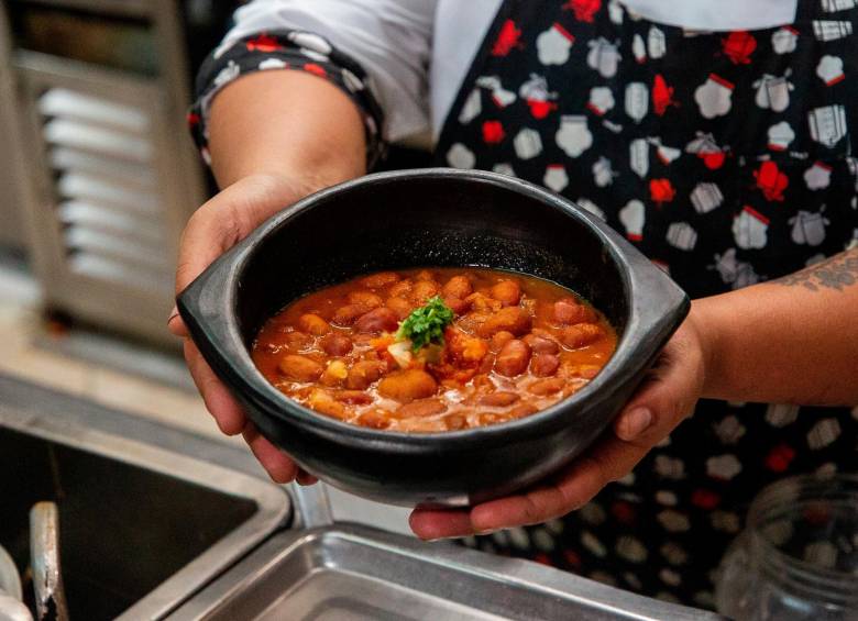 Mujer En Delantal Cocinando Deliciosa Sopa En Olla En La Cocina