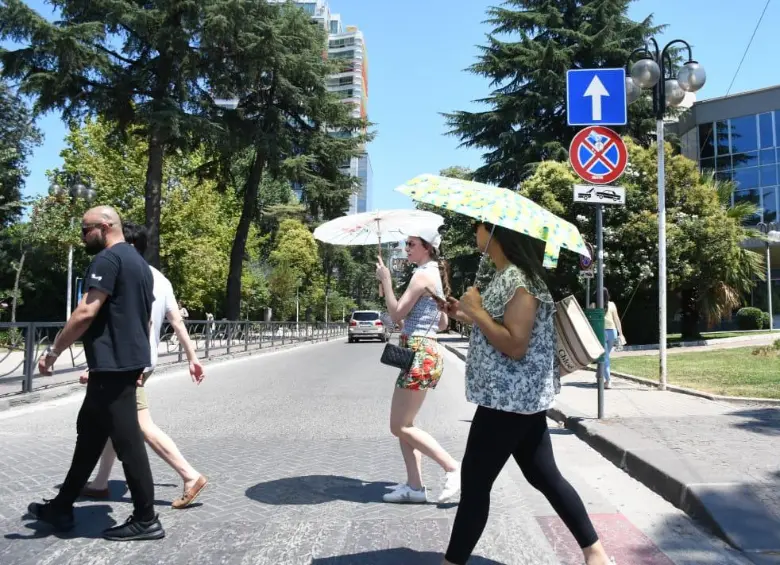 Las personas van con sombrillas debido al intenso calor. FOTO: AFP