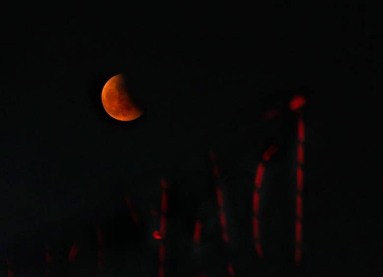 Según explica la Nasa, lo que ocurre es que la luz del Sol choca con los gases de la atmósfera terrestre y, debido a su longitud de onda más larga la luz roja no se dispersa fácilmente. Parte de esa luz roja se refracta, o se desvía, a medida que atraviesa la atmósfera de la Tierra y termina brillando en la Luna con una luz roja fantasmal. Imagen tomada en la India. FOTO EFE. 