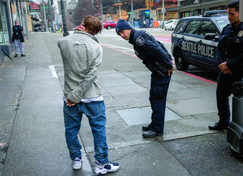 Fotografía de marzo de 2022, cuando se vio el auge de la adicción al fentanilo. Aquí se ve a agentes de policía atendiendo a un hombre que dijo estar fumando fentanilo en el centro de Seattle, Washington. Foto: Getty 
