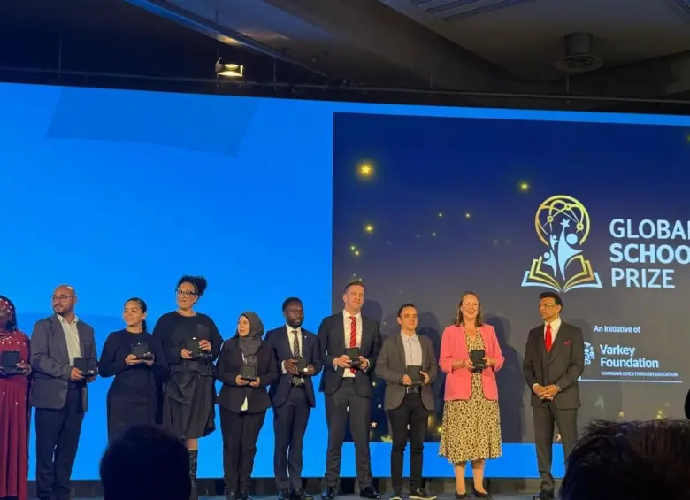 El docente Alexánder Echeverri, a la izquierda de la señora con blusa rosa, recibiendo el premio en Londres en el Global Schools Prize 2026. FOTO Cortesía