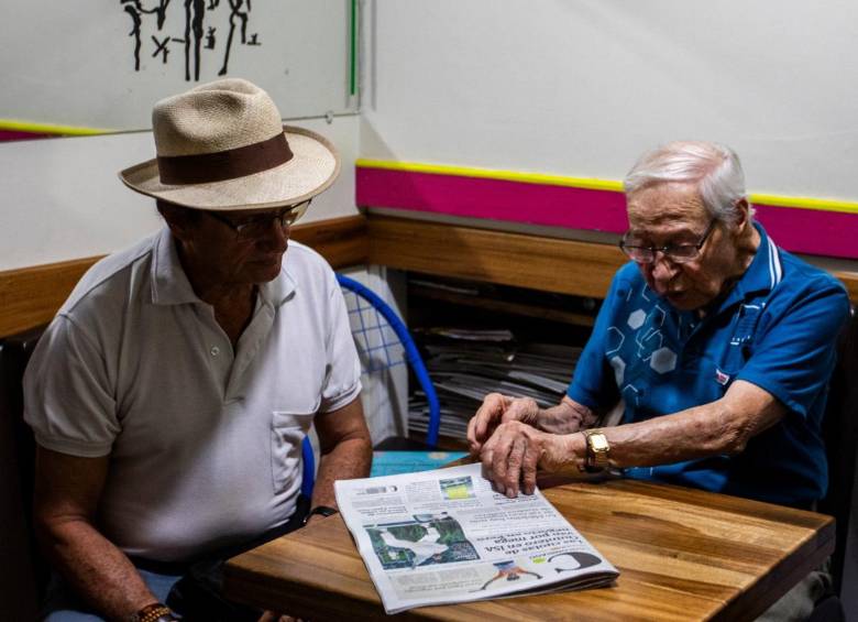 Mauro Bedoya junto a uno de sus fieles amigos, con una edición impresa de el periódico El Colombiano. FOTO Julio César Herrera.