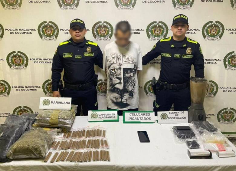 El capturado en Barrio Antioquia junto con la marihuana que fue incautada en la propiedad que servía como acopio ilegal. FOTO Policía Metropolitana. 