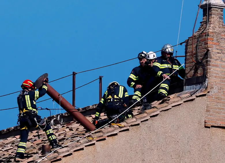 Una brigada de bomberos del Vaticano subió al hastial del tejado de la Capilla Sixtina para instalar la chimenea sin que la mayoría de turistas y fieles en San Pedro lo notara. FOTO: GETTY