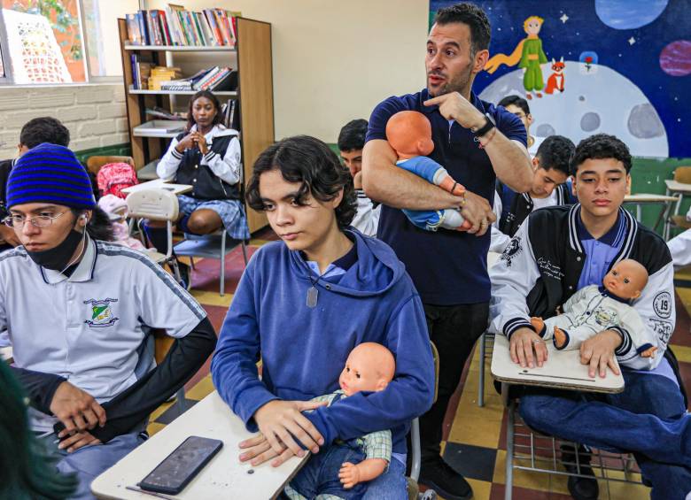 El profesor Manuel Ramírez (de pie) en una de sus clases cargando uno de los “bebés” de sus alumnos. FOTO: Manuel Saldarriaga.