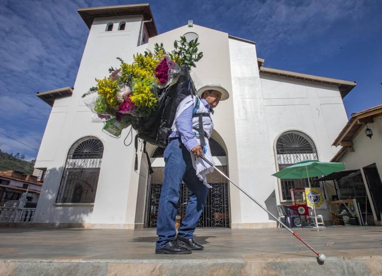 Jorge Agudelo cargando su silleta cerca de la parroquia Nuestra Señora de la Ternura de Copacabana donde tiene su puesto. Foto: Esneyder Gutiérrez