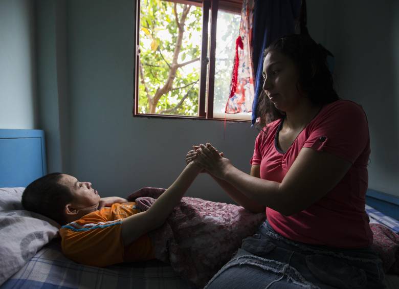 Una mujer cuida de un paciente en su casa. Foto: EL COLOMBIANO