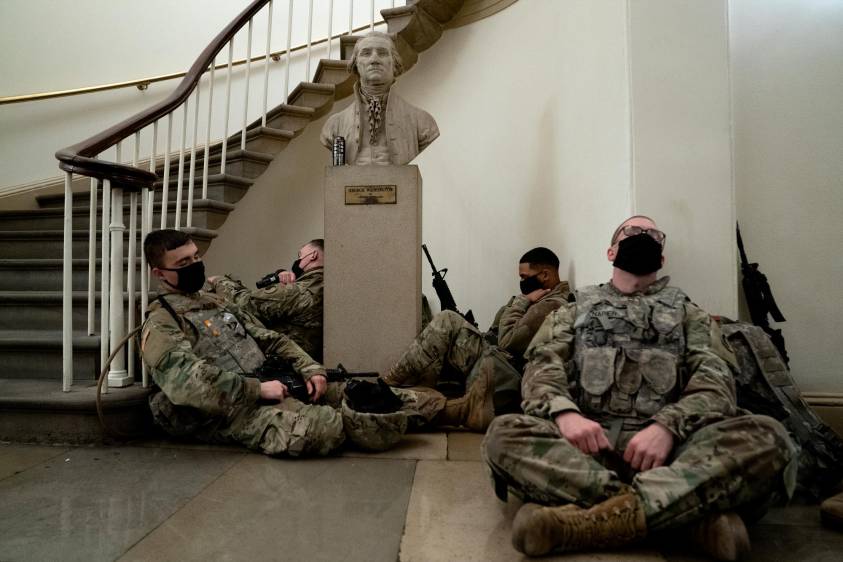Miembros de la Guardia Nacional de los Estados Unidos duermen en los pasillos del Capitolio para prevenir nuevos desmanes, horas antes del debate por el juicio político a Donald Trump por la invasión de este recinto por parte de sus seguidores. Fotos: Kent Nishimura (Los Angeles Times) vía Getty.