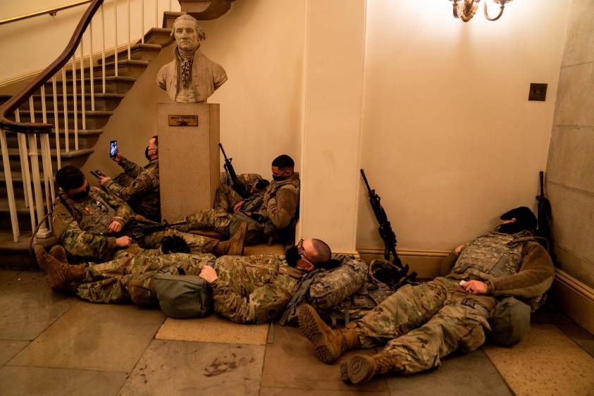 Miembros de la Guardia Nacional de los Estados Unidos duermen en los pasillos del Capitolio para prevenir nuevos desmanes, horas antes del debate por el juicio político a Donald Trump por la invasión de este recinto por parte de sus seguidores. Fotos: Kent Nishimura (Los Angeles Times) vía Getty.