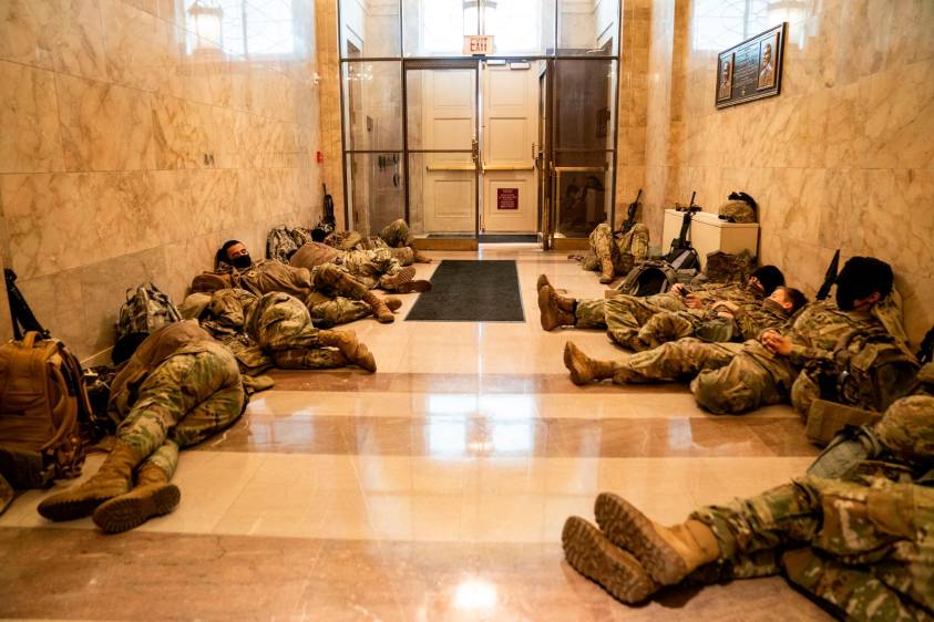 Miembros de la Guardia Nacional de los Estados Unidos duermen en los pasillos del Capitolio para prevenir nuevos desmanes, horas antes del debate por el juicio político a Donald Trump por la invasión de este recinto por parte de sus seguidores. Fotos: Kent Nishimura (Los Angeles Times) vía Getty.
