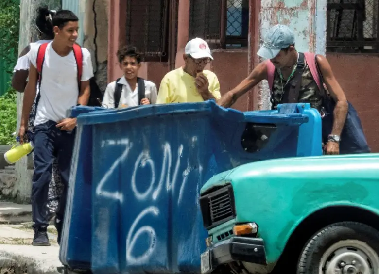 Un hombre hurga en un contenedor de basura en La Habana. La mendicidad en Cuba está asociada a la pobreza extrema, el abandono familiar y problemas de salud mental. FOTO: AFP