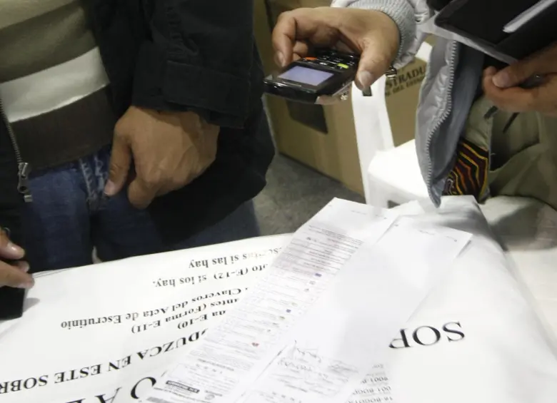 Testigo electoral toma una fotografía del formulario E-14 con su celular. Foto: Colprensa - Christian Castillo