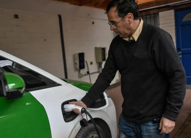 Imagen del 20 de agosto de 2024 del conductor chileno, Gabriel Garrido, cargando un automóvil eléctrico chino después de participar en una entrevista con la Agencia de Noticias Xinhua, en Santiago, capital de Chile. Garrido muestra con orgullo su auto eléctrico de la marca china BYD, tras participar con éxito en el programa del Gobierno del país sudamericano Mi taxi eléctrico, que incentiva a cambiar los antiguos autos a combustión por máquinas 100 por ciento eléctricas. FOTO: Xinhua