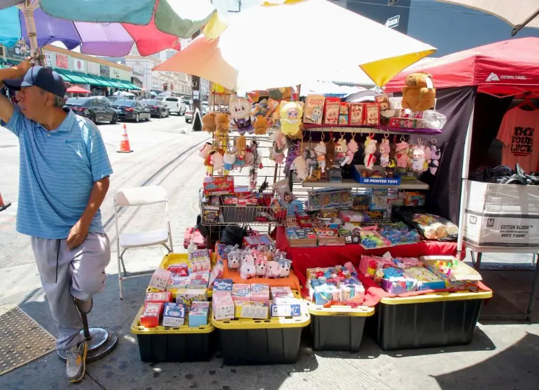 Manuel Suárez, un vendedor ambulante de juguetes, se encuentra en su puesto en una esquina de Los Ángeles. FOTO: AFP.