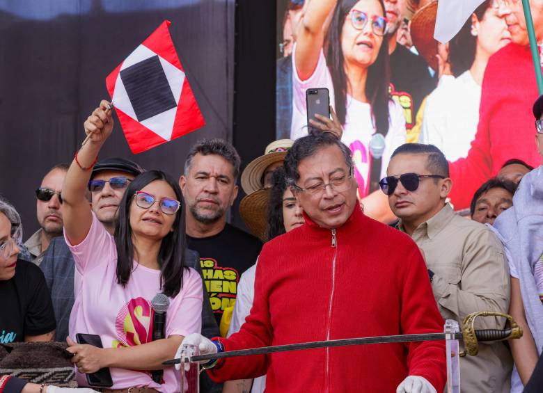Angie Rodríguez junto al presidente Petro en la Plaza de Bolívar de Bogotá el 1 de mayo de 2025 con la bandera de Guerra a Muerte. FOTO Presidencia