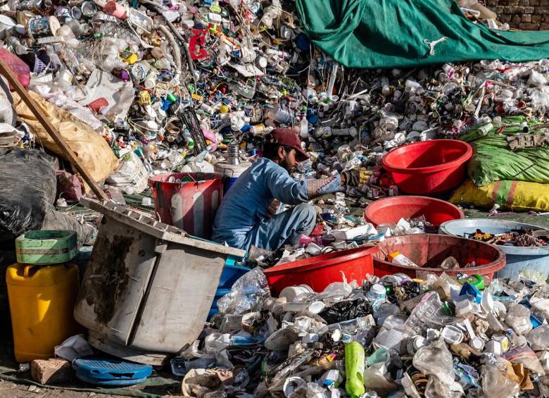 Un trabajador afgano clasifica el plástico reciclable recogido en un depósito de reciclaje en las afueras de Kabul. FOTO: AFP