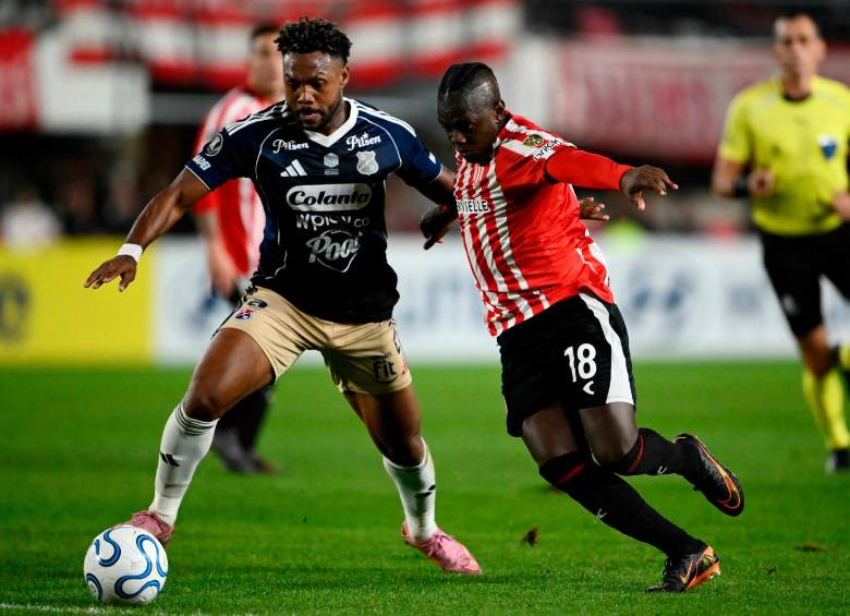 El lateral colombiano Léyser Chaverra, del DIM, y el extremo vallecaucano Edwuin Cetré, de Estudiantes, disputan un balón en el estadio de La Plata, en Argentina. Foto: AFP