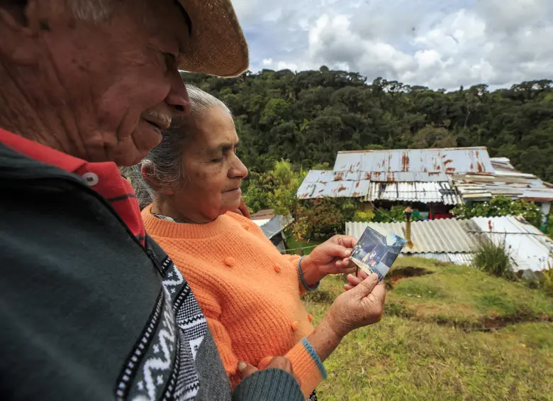 Don Rodrigo y su esposa contemplan una foto antigua de la finca de La Linda que fue volada por la guerrilla. Foto: Andrés Camilo Suárez Echeverry