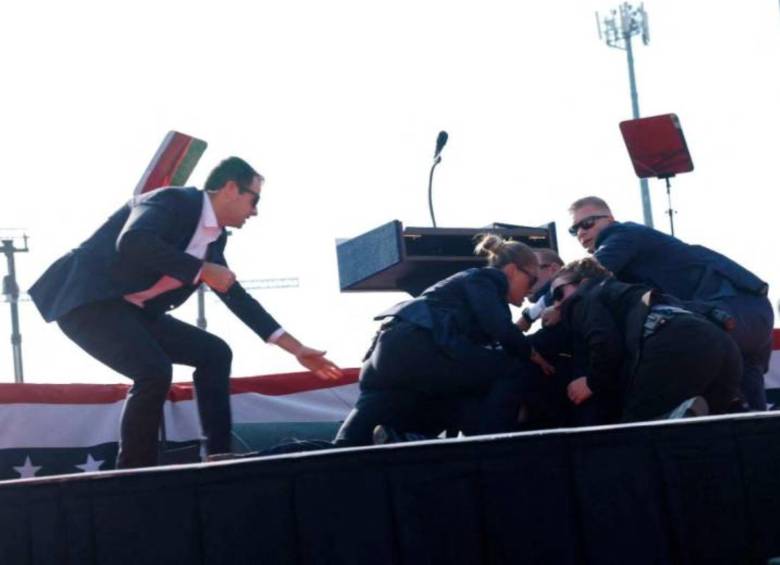 Los del Servicio Secreto protegiendo a Donald Trump después de ser atacado. FOTO: AFP