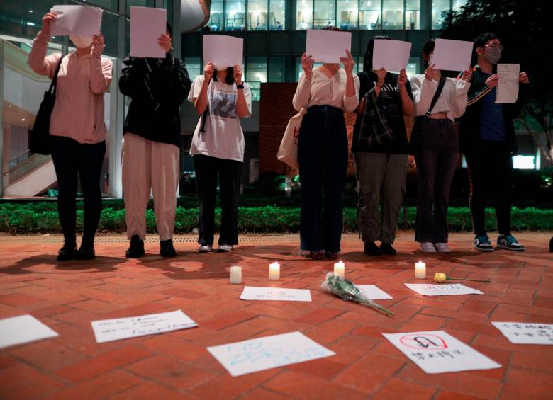 Estudiantes de China continental sostienen hojas de papel en blanco durante una vigilia por las víctimas de la política de cero COVID de China y las víctimas del incendio de Urumqi en la Universidad de Hong Kong en Hong Kong, China, el 29 de noviembre de 2022. FOTO: EFE
