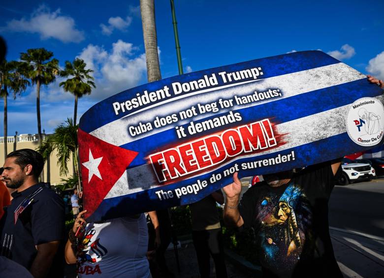 Varias personas sostienen un cartel frente al restaurante Versailles en Miami, Florida, en apoyo a los cargos presentados por la fiscalía federal estadounidense contra el expresidente cubano Raúl Castro. Se han avivado las especulaciones sobre un posible intento del presidente Donald Trump de derrocar al régimen comunista. Foto: AFP
