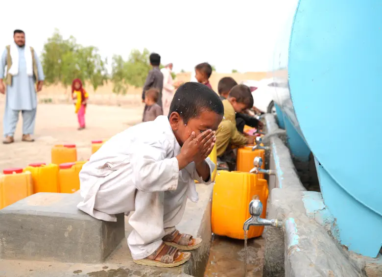 Niños afganos recogen agua de un camión cisterna en Kabul, donde el acceso al líquido vital es cada vez más limitado. CRÉDITO: UN- HABITAT AFGHANISTAN