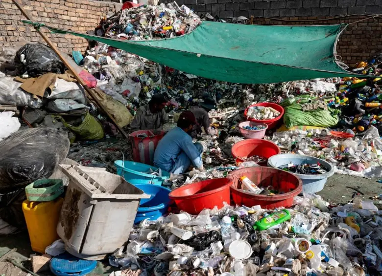 Una persona rodeada de envases de plástico. FOTO: AFP