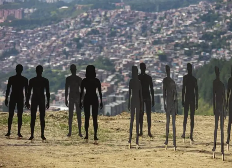 Siluetas de personas son utilizadas para conmemorar a las víctimas en La Escombrera, en la Comuna 13 de Medellín, donde continúan las labores de remoción de tierra. FOTO Manuel Saldarriaga 