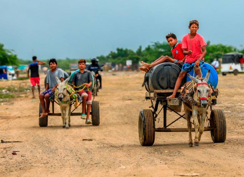 Los burros cargados con agua para la venta recorren todo el asentamiento desde las 6:00 de la mañana hasta las 7:00 de la noche. FOTO: Camilo Suárez. 
