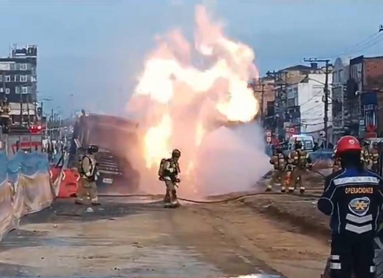 Los bomberos de la ciudad intentando controlar el incendio aparentemente provocado por el choque entre vos vehículos dentro de una obra en Bogotá. FOTO: CAPTURA VIDEO TRÁNSITO BOGOTÁ