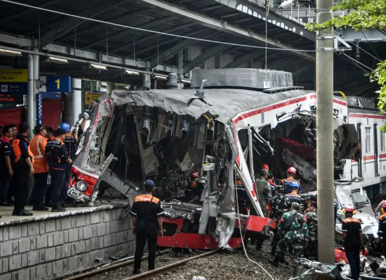 Equipos de rescate y trabajadores inspeccionan los restos de los trenes involucrados en el choque ocurrido en la estación Bekasi Timur, en las afueras de Yakarta, Indonesia. FOTO: AFP. 