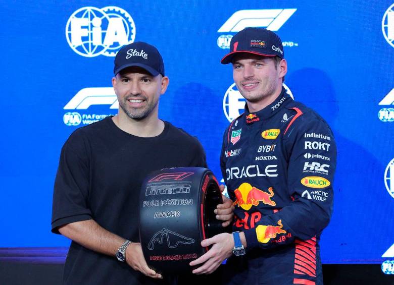 Sergio Kun Agüero le entrega el premio de la pole position a Max Verstappen. FOTO F1