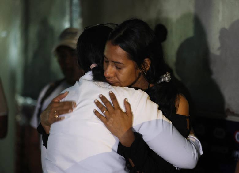 Dos mujeres reaccionan mientras participan en una oración, mientras familiares de presos esperan frente a la cárcel de El Rodeo, en Caracas, el 9 de enero de 2026 Foto: AFP