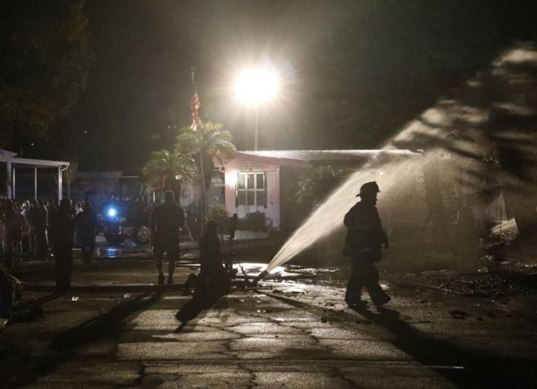 Los vecinos y familias de las viviendas afectadas tras el choque de la aeronave mientras los bomberos continúan apagando las llamas. FOTO: Departamento de Bomberos de Clearwater/ AFP