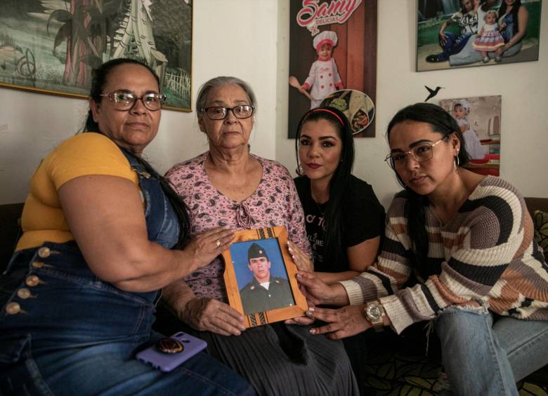De izquierda a derecha: Luz Mariela, Gilma Rosa, Millely y Claudia María. Gilma, en la sala de su casa, sostiene el retrato de Carlos Javier, quien prestó servicio militar.