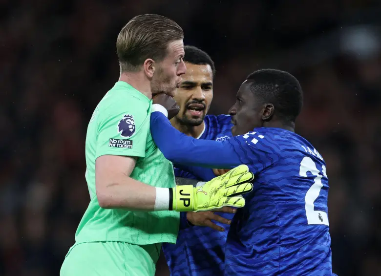 El arquero Jordan Pickford intentó frenar al senegalés Idrissa Gana Gueye, quien insistía en seguir peleando con su compañero. Foto: AFP
