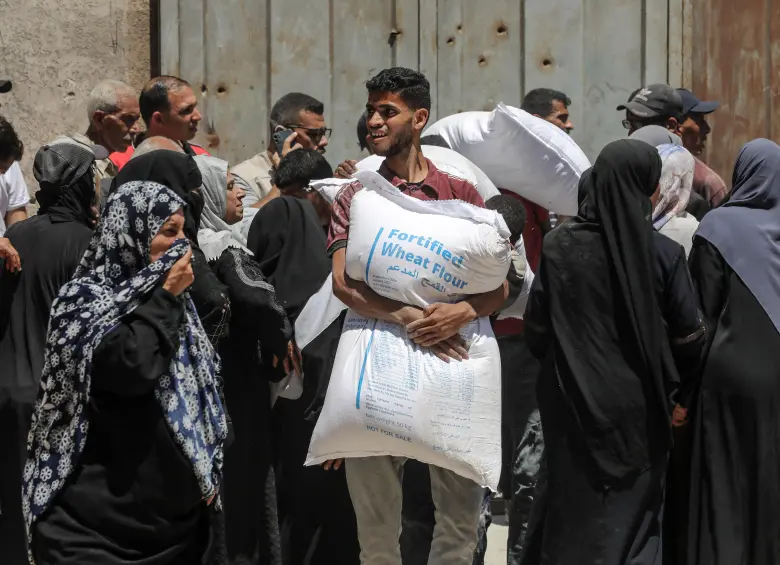 Palestinos se reúnen para recibir ayuda de alimentos en un punto de distribución de asistencia alimentaria, en la Ciudad de Gaza. FOTO: Xinhua