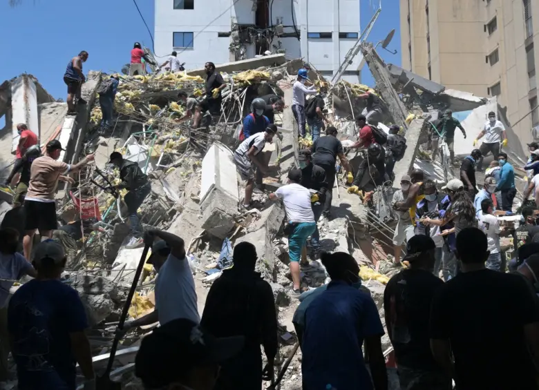 Los organismos de socorro ayudando a las personas atrapadas bajo los escombros. FOTO: AFP