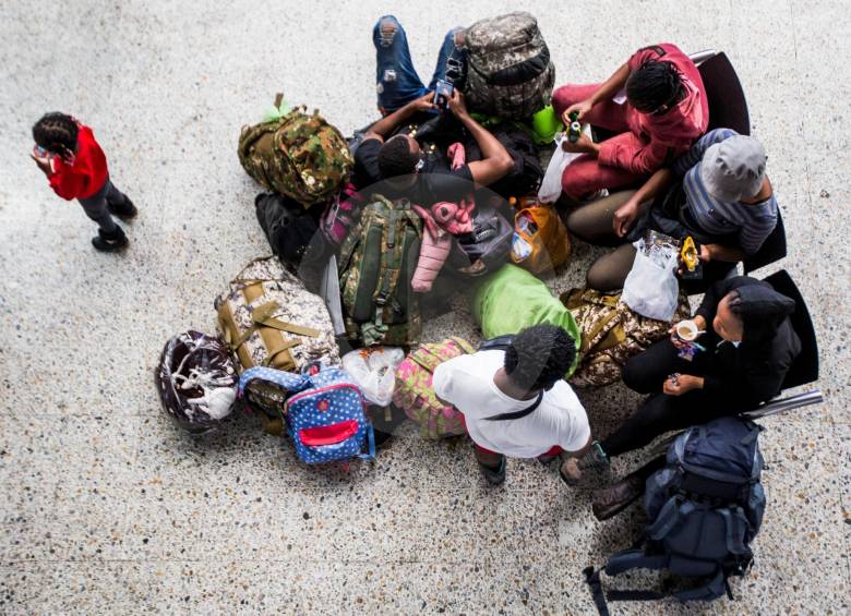 Grupos como estos llegan diariamente a la Terminal del Norte de Medellín. Los migrantes, en su mayoría, son haitianos, pero también se registra la llegada de cubanos. Estos esperan su turno para abordar el bus que los llevará a Necoclí. FOTO julio césar herrera