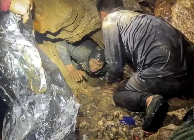 Esta es una captura de pantalla tomada de un video facilitado el 29 de mayo de 2026 por Metta Tham Rescue Kalasin y muestra a un equipo de rescate liberando a uno de los siete hombres (izquierda) atrapados en una cueva semisumergida en la provincia central de Xaysomboun, al noreste de la capital, Vientiane. Foto: AFP