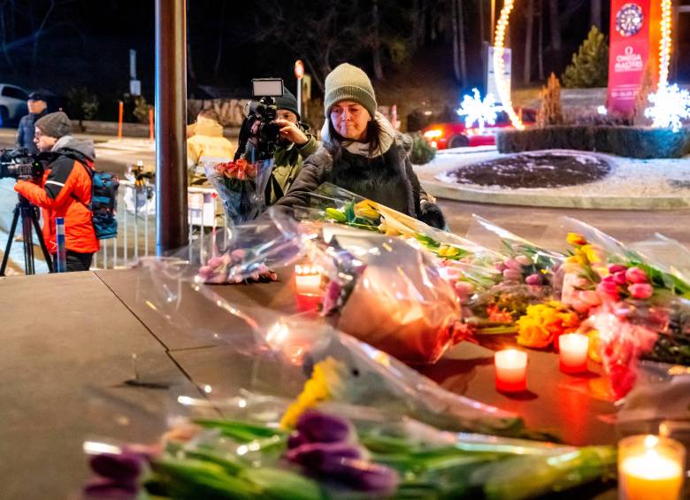 Una mujer pone flores cerca del lugar donde un incendio arrasó un bar abarrotado durante las celebraciones de Nochevieja en la ciudad de Crans-Montana. FOTO: AFP
