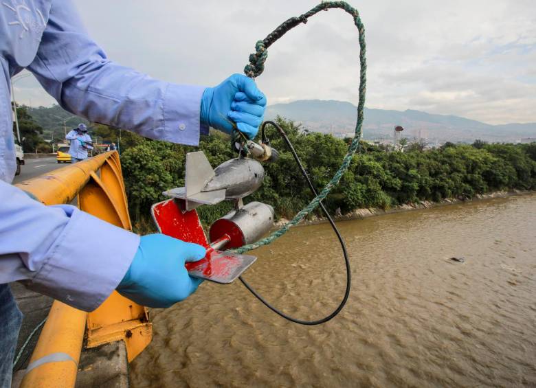 Un trabajador del Siata revisa uno de los sensores ubicados a lo largo del río Medellín para las labores de monitoreo. FOTO: Cortesía Área Metropolitana