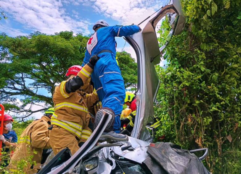 Bomberos e integrantes de la Cruz Roja sacando los cuerpos del vehículo particular. FOTO: REDES SOCIALES CRUZ ROJA COLOMBIANA 