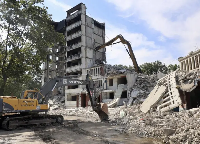 Excavadora desmantelando un edificio destruido en Ucrania por un ataque ruso. FOTO: AFP