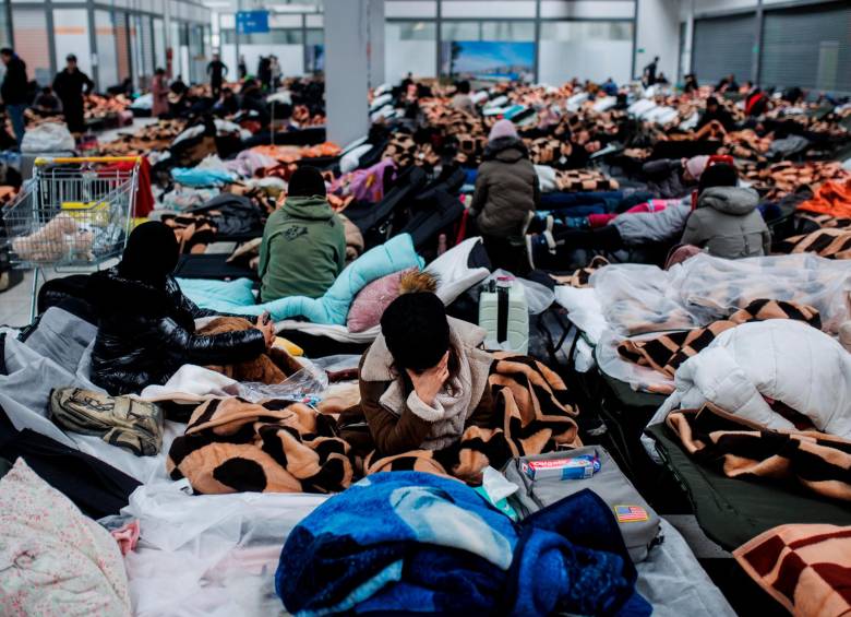 Refugiados descansan en un centro comercial destinado a la recepción temporal en Polonia. FOTO GETTY
