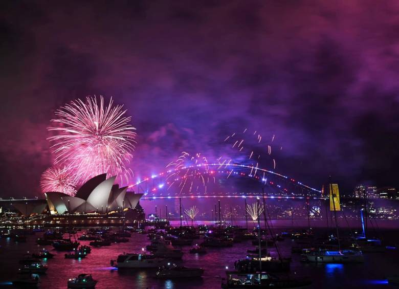 Los “fuegos artificiales familiares” iluminan la Ópera y el Puente del Puerto de Sídney, tres horas antes del espectáculo principal a medianoche en Sídney la víspera de Año Nuevo del 31 de diciembre de 2024. (Foto de Saeed KHAN / AFP)